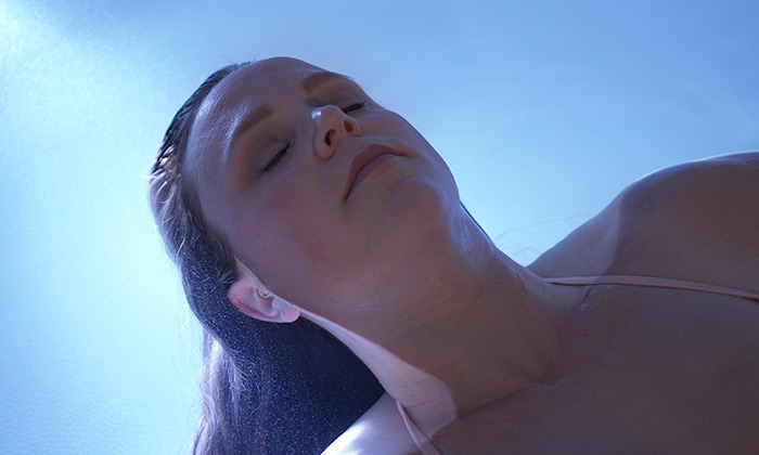 A woman floating gently, relaxed in our floatation tank.